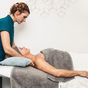 Terapeuta realizando un tratamiento en una persona acostada en una camilla.