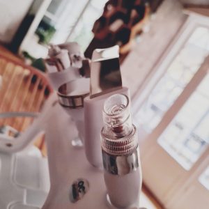 Dispositivo de tratamiento facial con boquillas y detalles metálicos en primer plano.